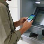 client ferme son application bancaire devant distributeur automatique