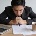 Employe assis devant bureau anxieux remplissant formulaires