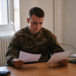 Militaire en uniforme consulte document solde financier