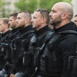 Officiers en uniforme noir alignes avec equipements tactiques.