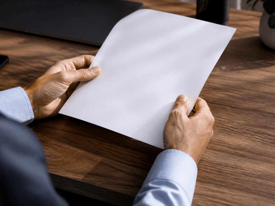 Deux mains tenant un document bancaire sur un bureau