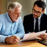 Personne agee assise consultant documents financiers avec avocat