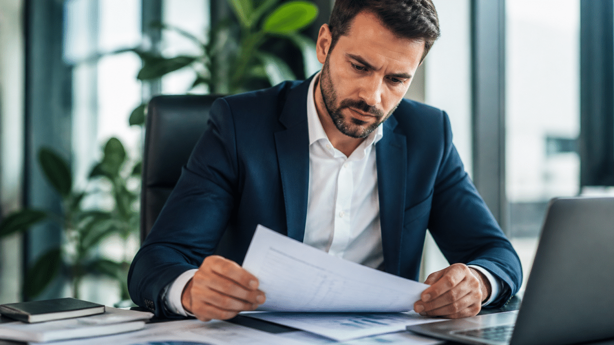 Homme consultant document financier assis a son bureau